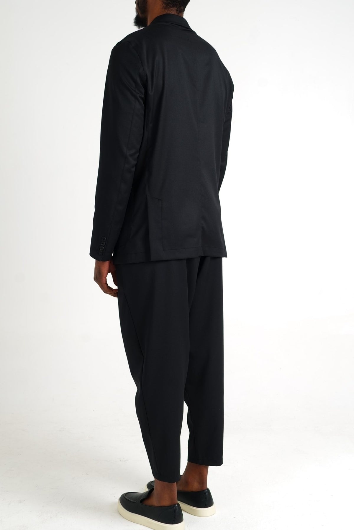 Costume d'été noir vu de dos, veste à fentes et pantalon à pinces