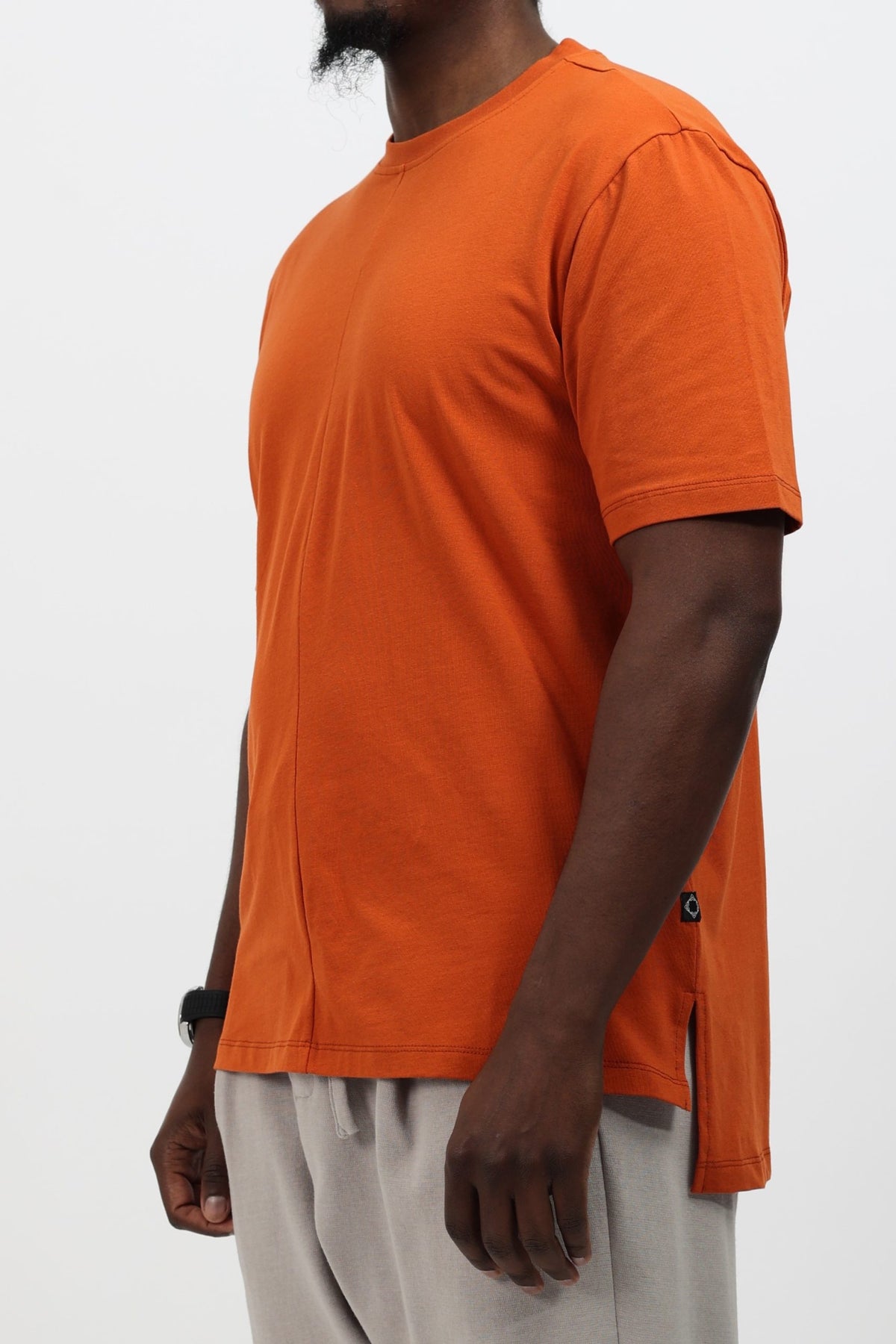 T-shirt long homme Classy orange rouille porté de trois quarts, bas asymétrique