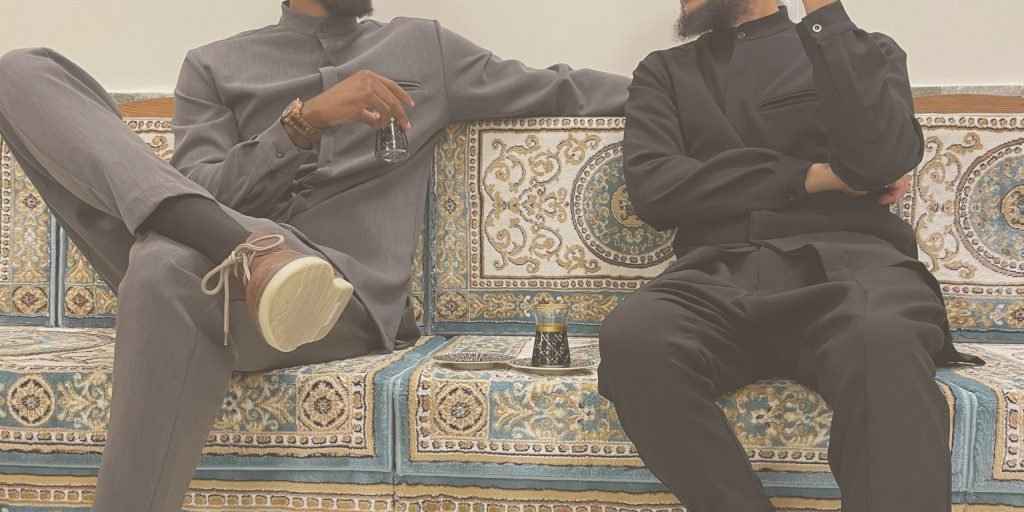 Hommes en tenues EMIR grise et noire sur une banquette, couleurs de l'automne 2024