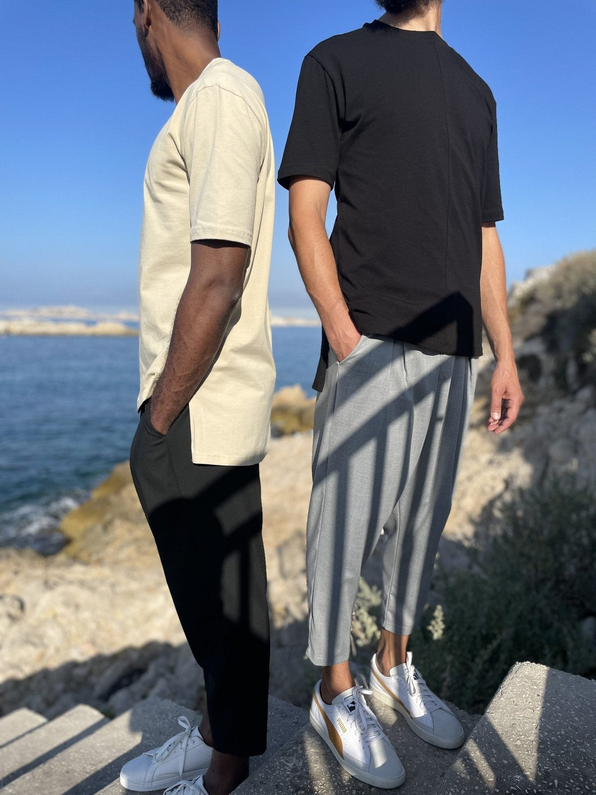 Deux hommes en t-shirts beige et noir au bord de la mer, le t-shirt homme basique