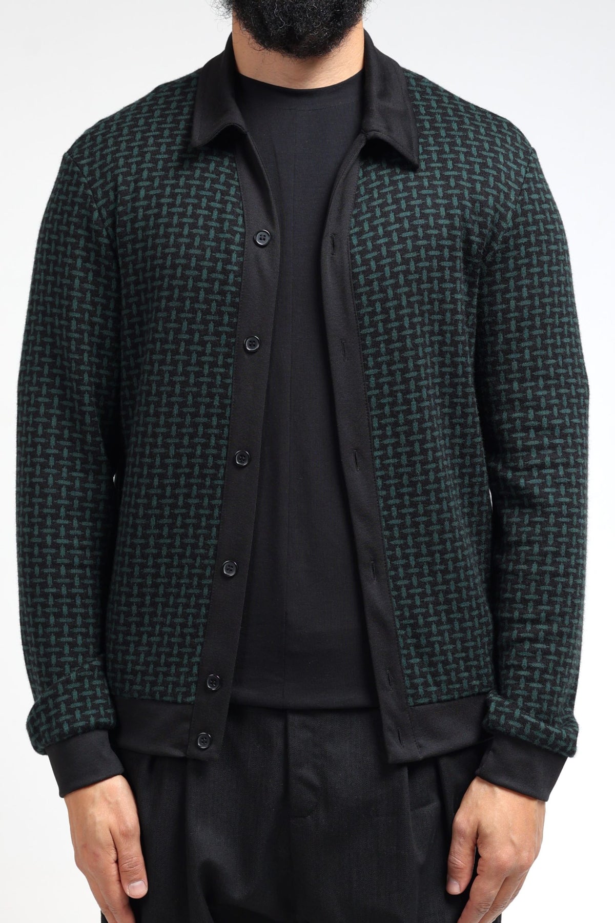 Gilet col polo homme noir et vert cachemire porté ouvert sur un t-shirt noir
