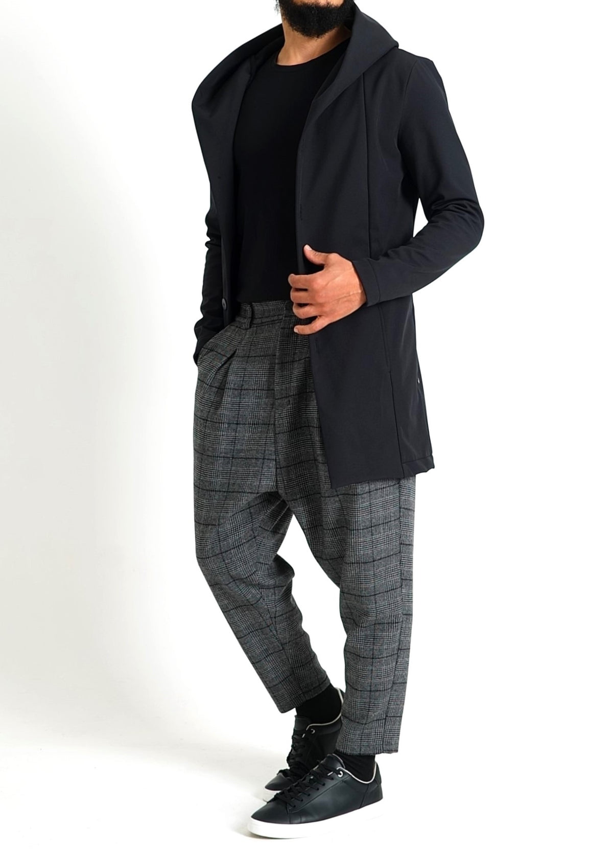 Cardigan long homme noir porté avec un pantalon à carreaux gris