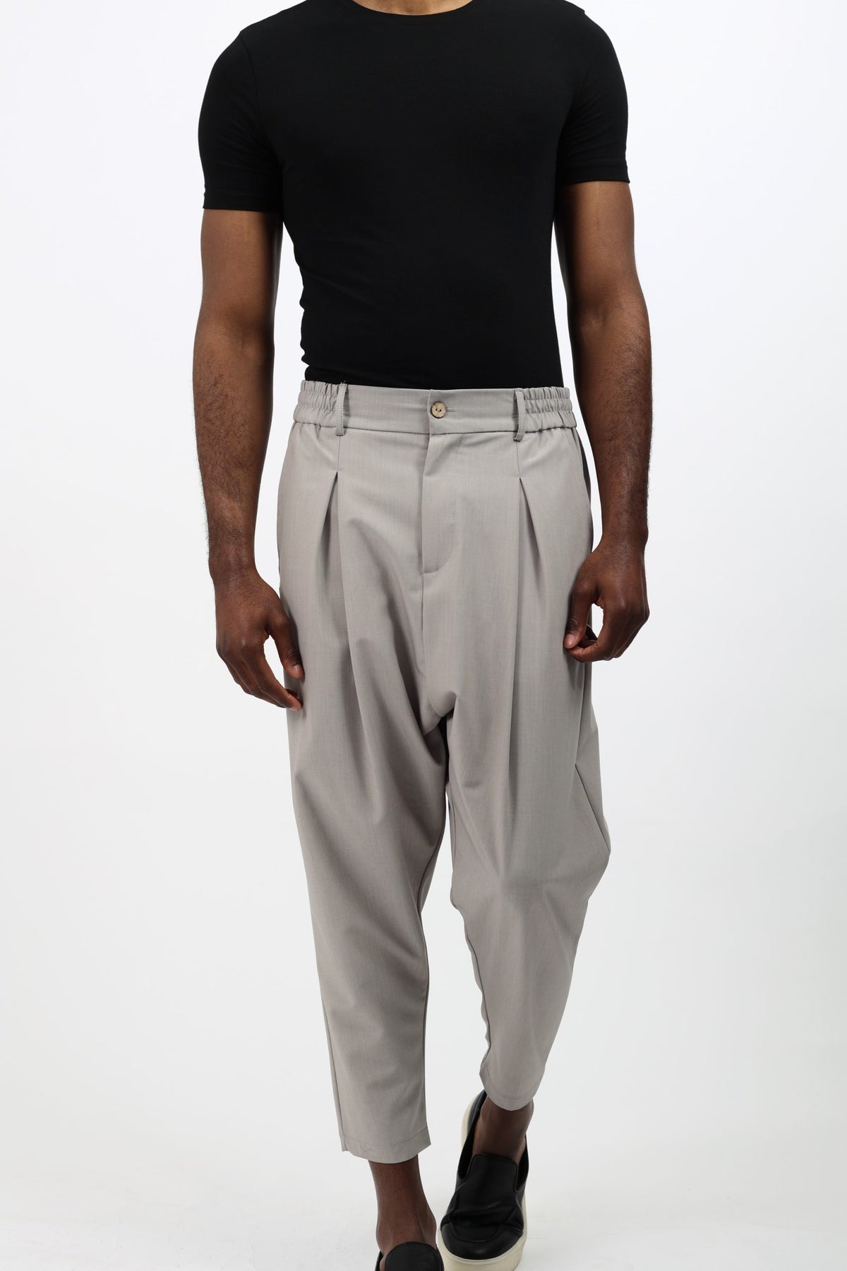 Pantalon Noragi mi-saison gris clair porté avec un t-shirt noir