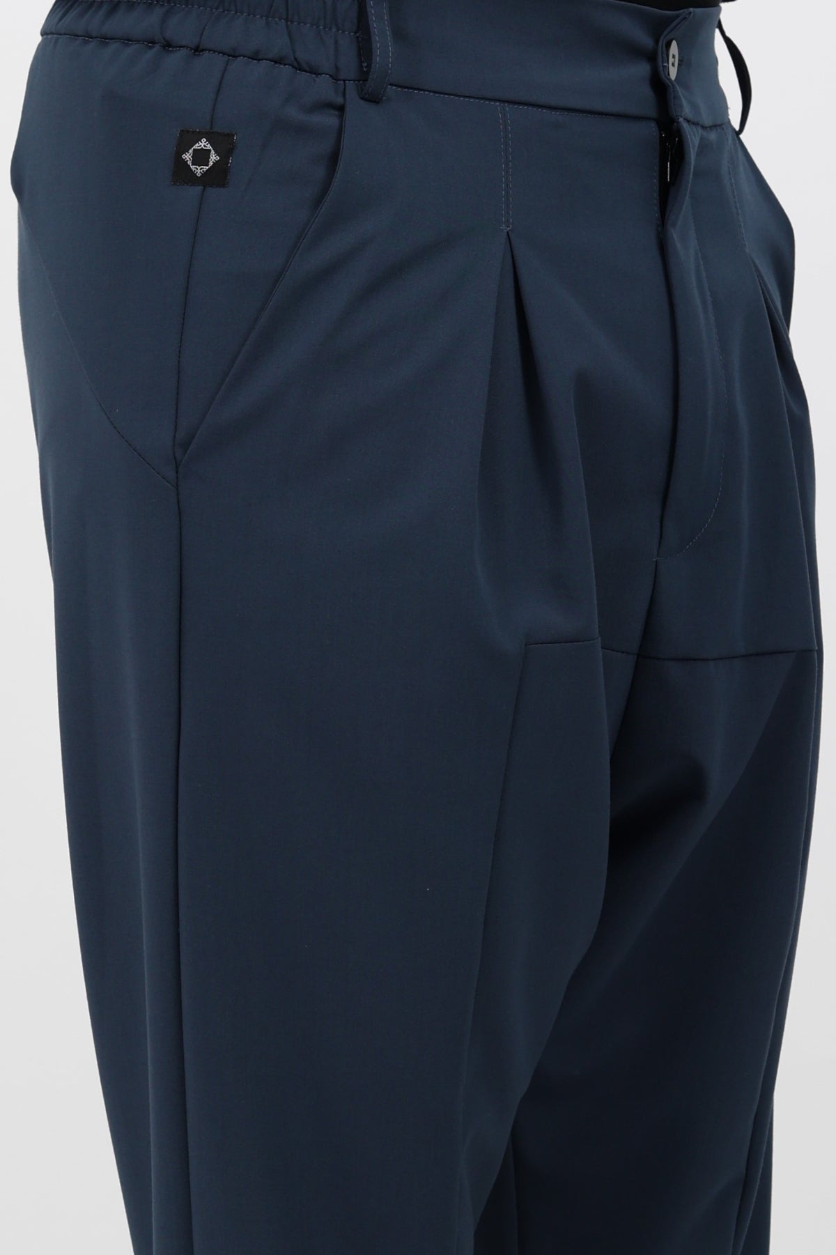 Détail des pinces et de la taille du sarouel NewFit mi-saison bleu pétrole