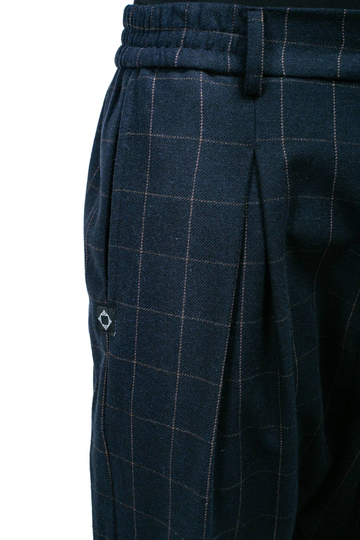 Détail des pinces et de la taille semi-élastique du pantalon Noragi à carreaux