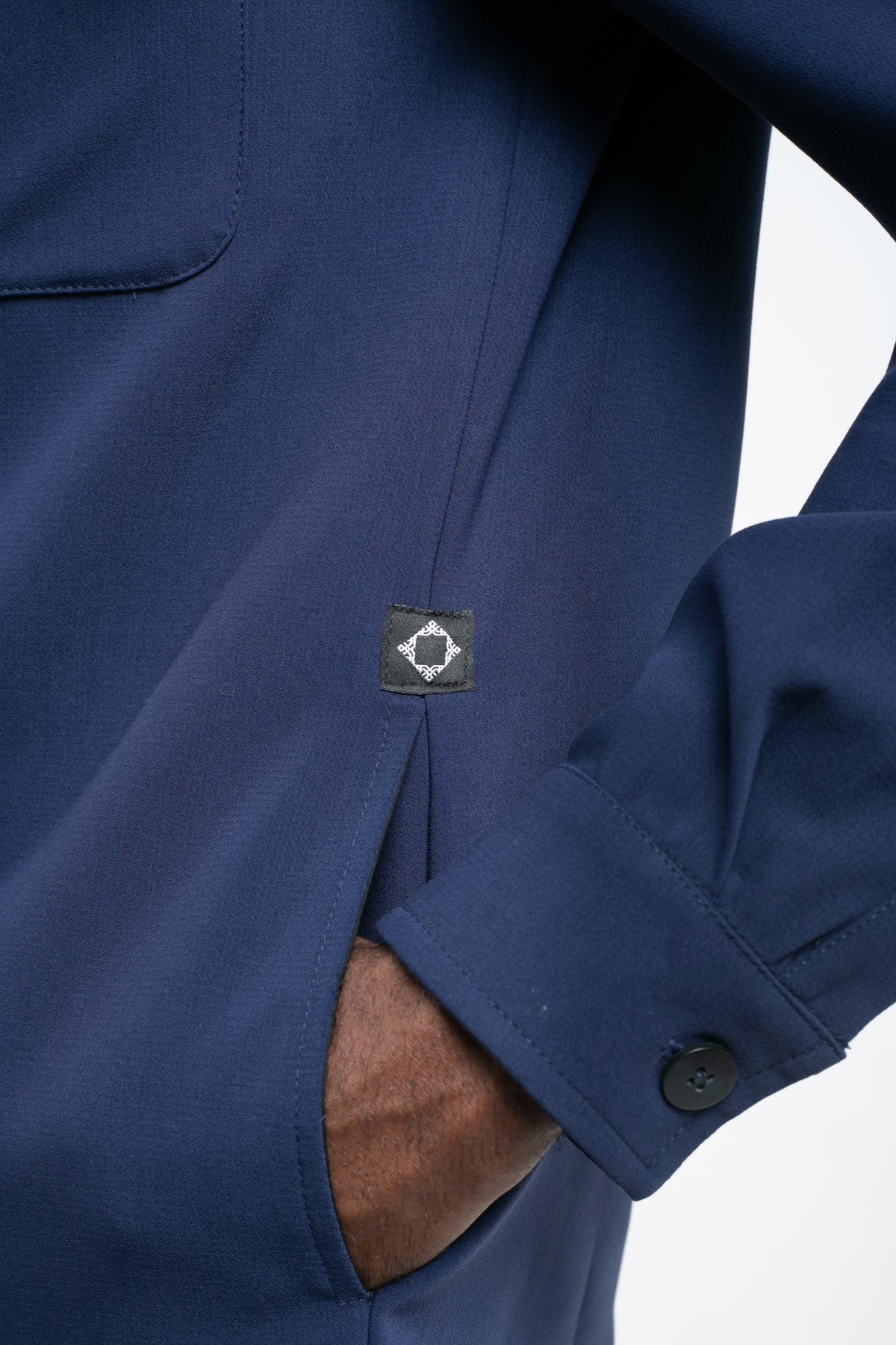 Détail du poignet et du logo de la veste Amarin bleu marine