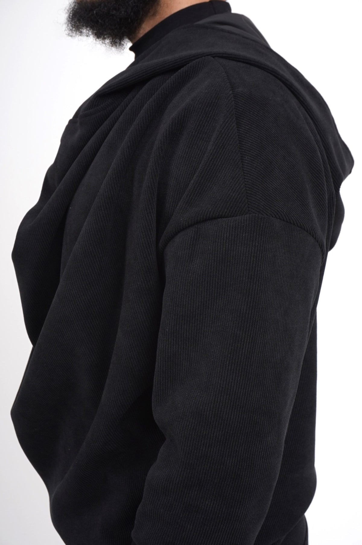 Détail de l'épaule tombante et du velours côtelé du pull Boho noir