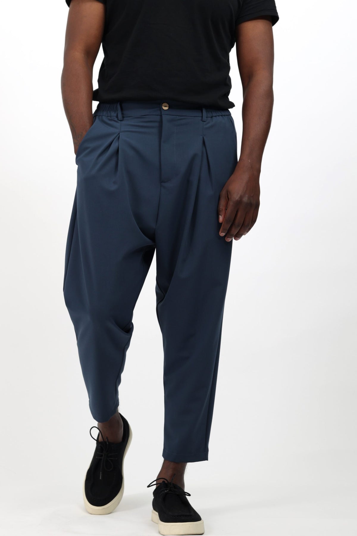 Pantalon Noragi mi-saison bleu pétrole porté avec un t-shirt noir