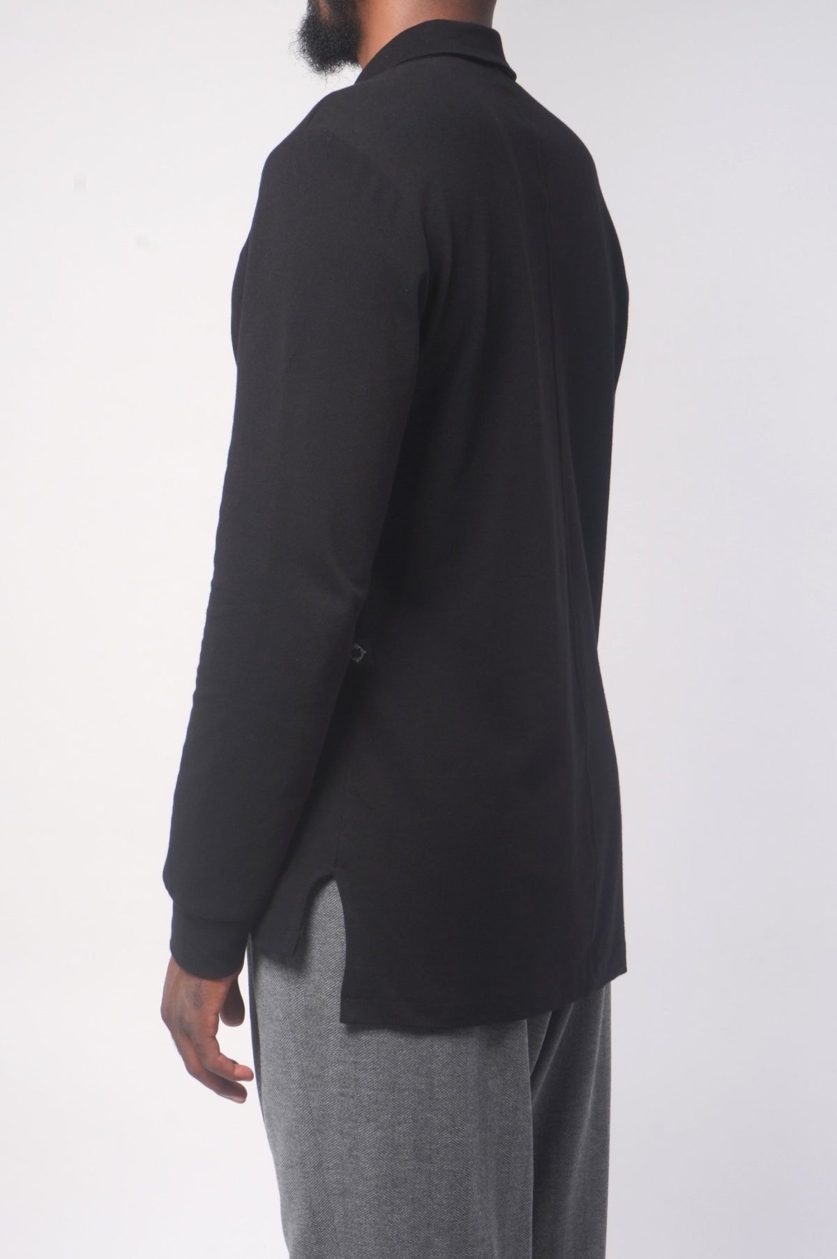 Polo Classy noir de profil, fente latérale et bas asymétrique