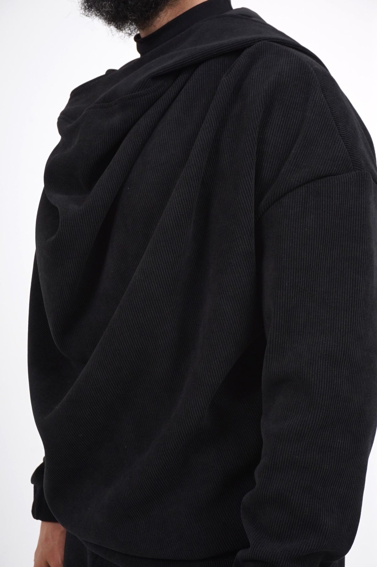 Détail du col drapé volumineux du pull Boho noir