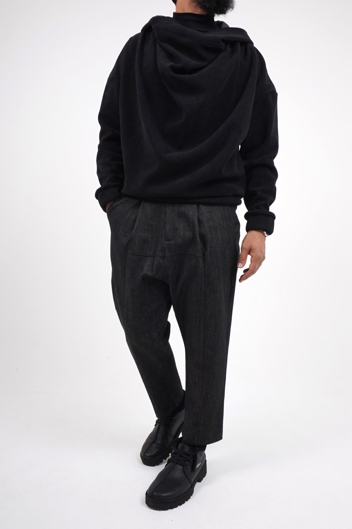 Pull Boho noir à col drapé porté de face avec un pantalon ample