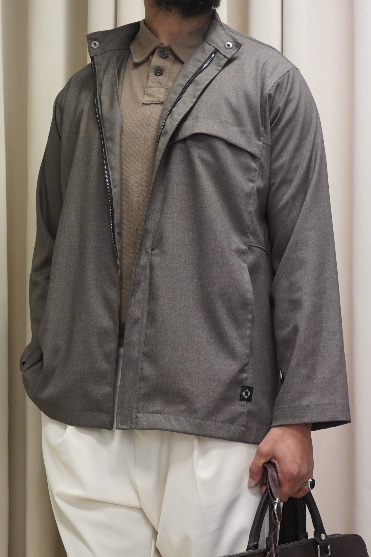 Veste Dunes marron glacé demi-zip portée avec un pantalon crème